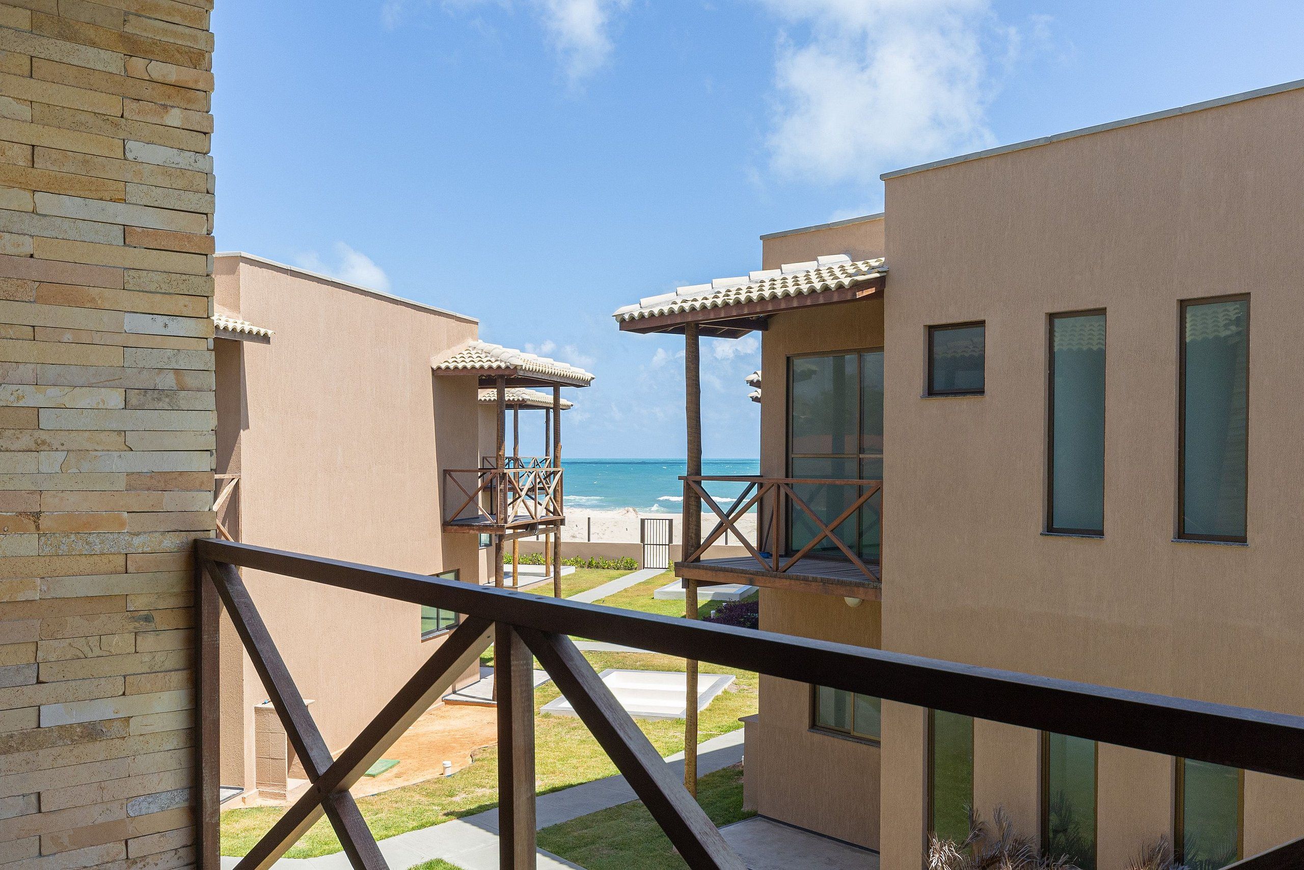 Um edifício moderno com varanda com vista para a praia.
