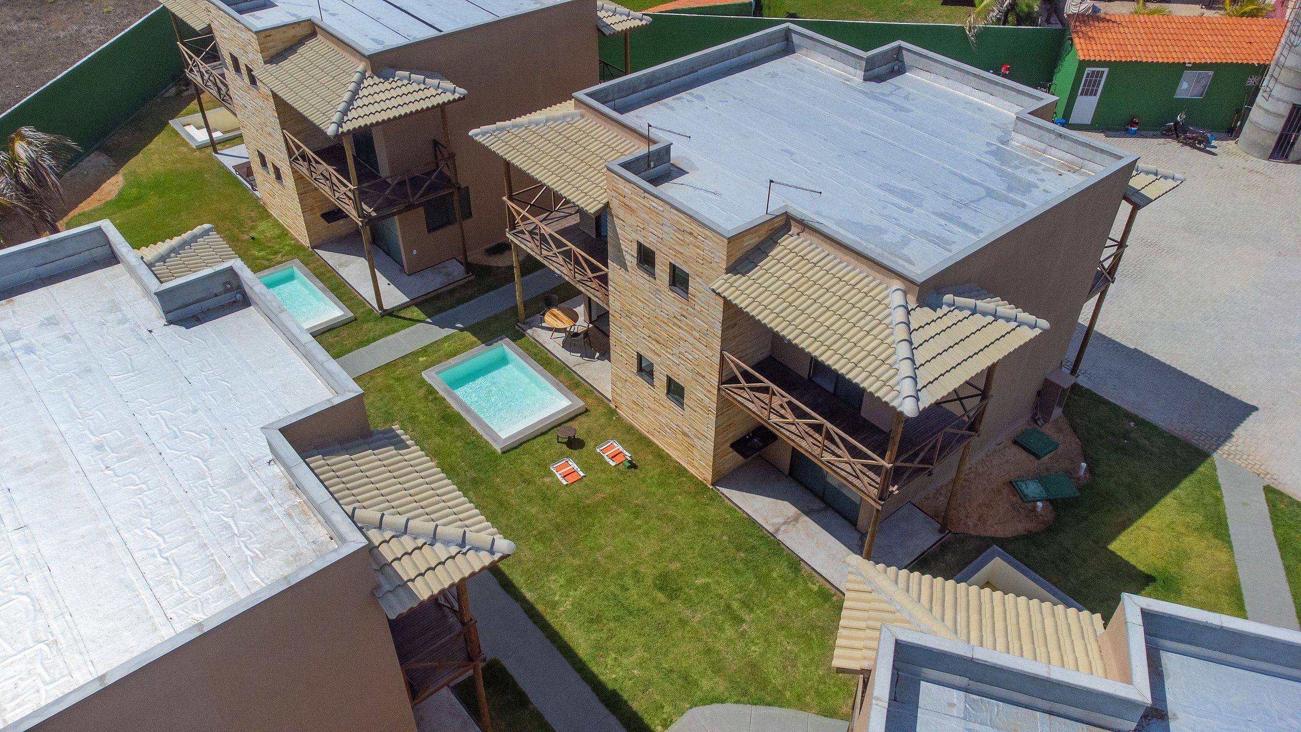 Um edifício de vários andares com piscina no terraço, área de estar ao ar livre e escadaria para uma varanda.