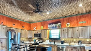 A spacious kitchen with wooden cabinets, a large island with seating, a ceiling fan, and a view of the dining area. - All Aboard for a stay you wont forget. Trestle View, get your tickets now. (Shenandoah)