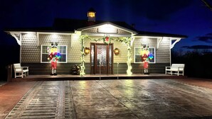 A house with a tiled exterior, a front porch with benches, and a lit front door. - All Aboard for a stay you wont forget. Trestle View, get your tickets now. (Shenandoah)