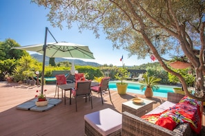 A wooden deck with outdoor furniture, a pool, and a view of the mountains. - "Le Patio" with Sea View, Wi-Fi, and Air Conditioning (Bormes-les-Mimosas)