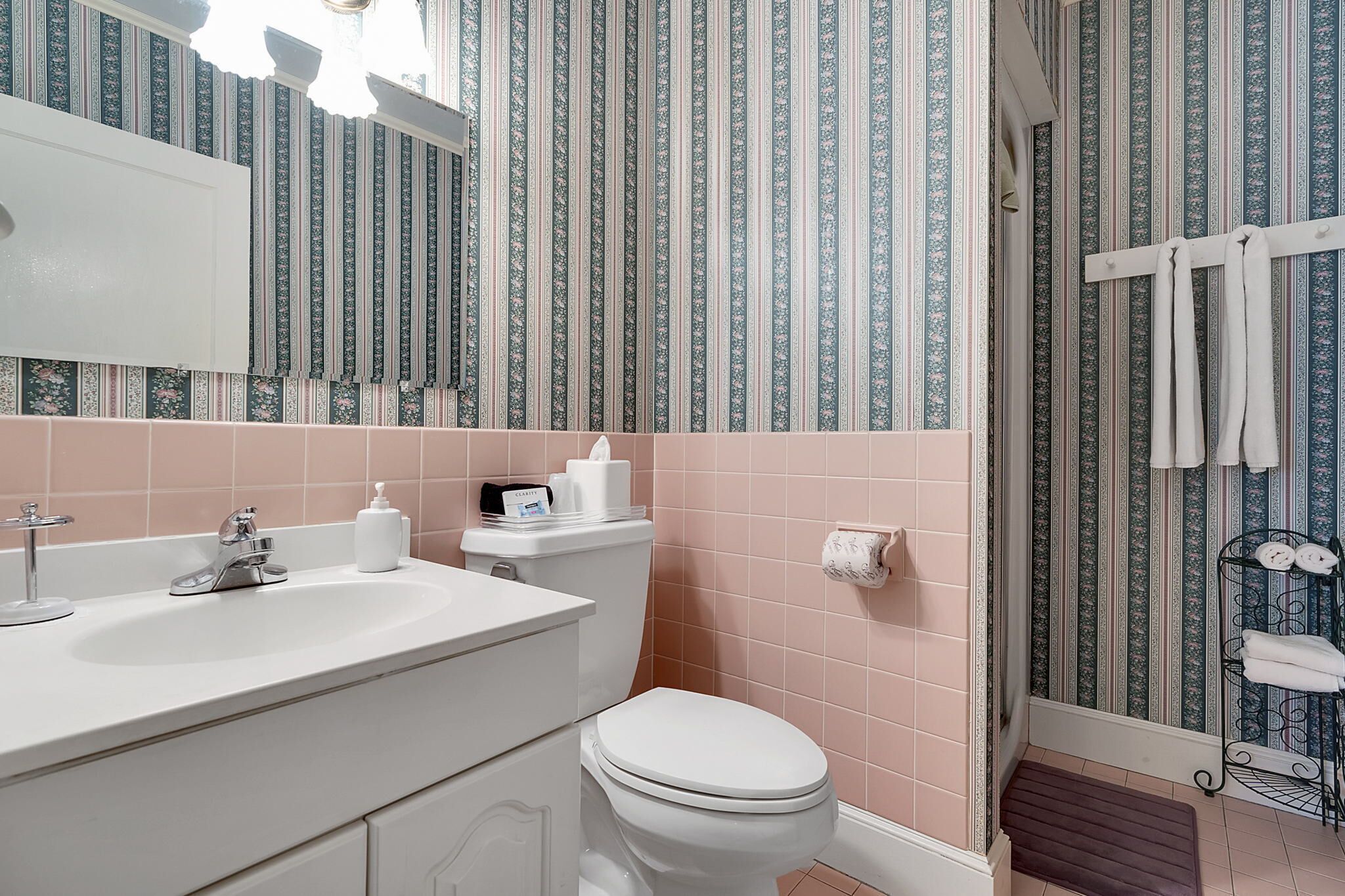 A bathroom with a white sink, toilet, and shower area.