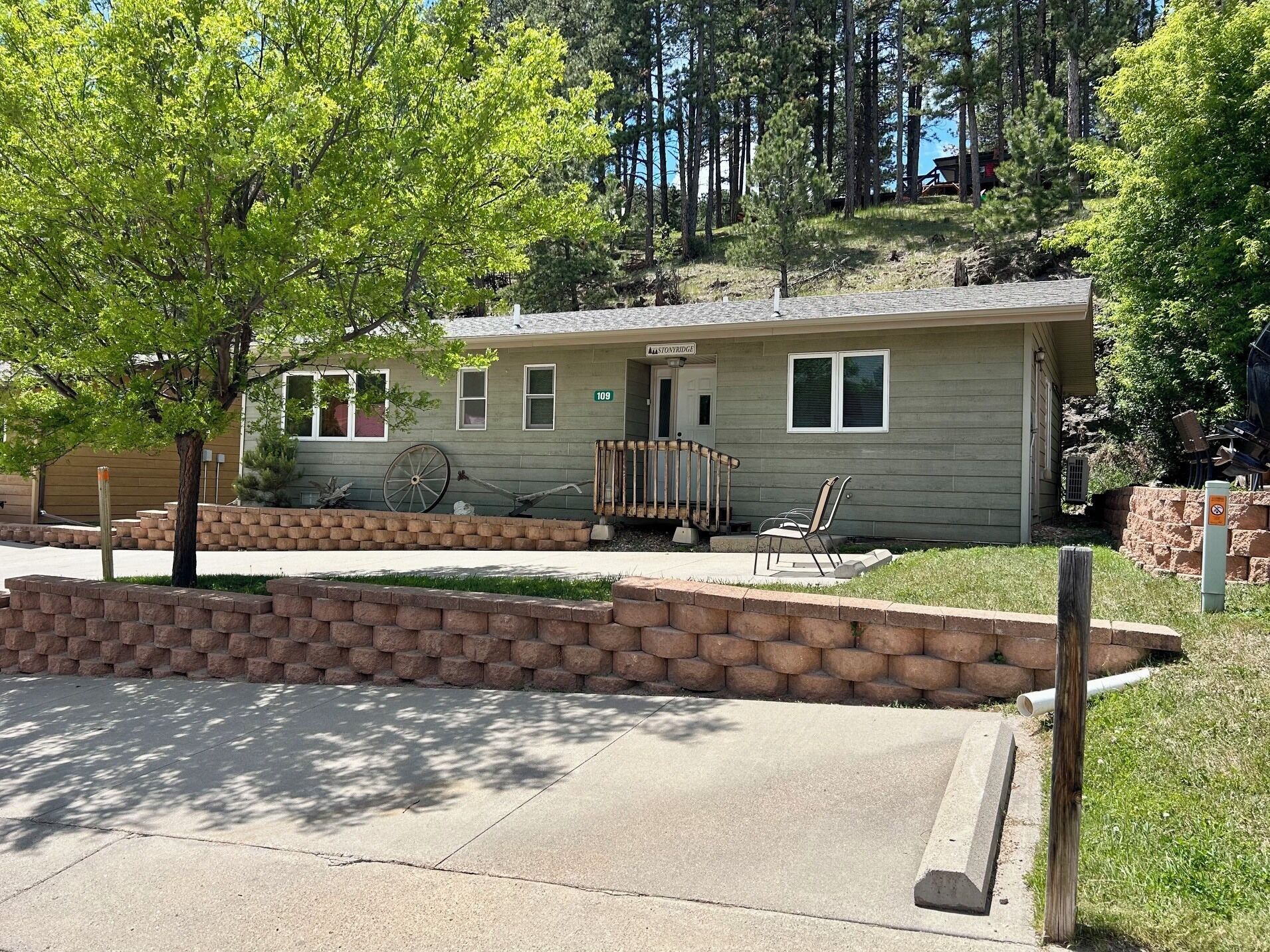 A single-story house with a porch, a wheelchair ramp, and a small front yard.