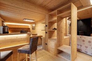 A wooden interior with a bar area, seating, and a fireplace.