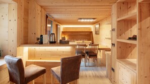 Un intérieur en bois comprenant un coin cuisine, une table à manger et des chaises.