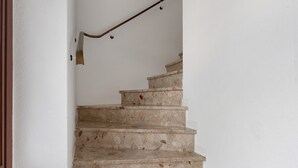 Uma escada com corrimão e luminária.