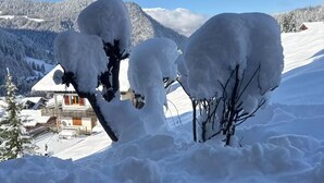 Paisagem coberta de neve com um edifício ao fundo.