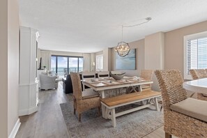Un espace repas comprenant une table, des chaises et un lustre.