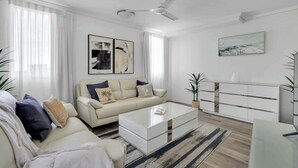 Un salon moderne avec un canapé, une table basse et un meuble blanc.