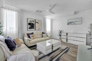 Ein modernes Wohnzimmer mit einer Couch, einem Couchtisch und einem weißen Schrank.