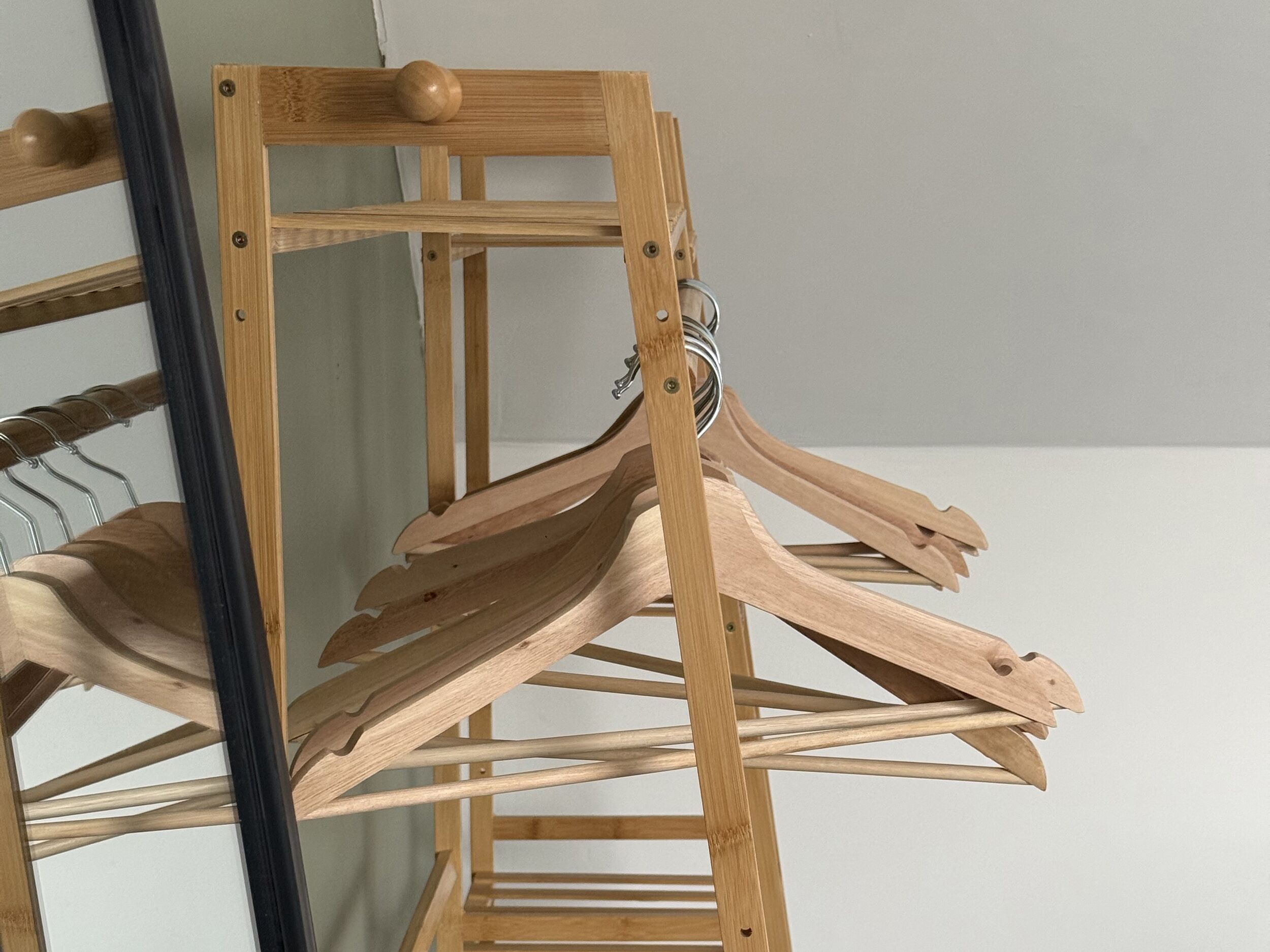 A wooden drying rack with multiple hangers.