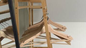 A wooden drying rack with multiple hangers.