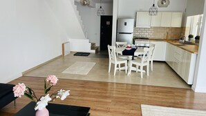 A modern apartment with a dining area, kitchen, and staircase. - Galaxy Residence Villa (Odăile)