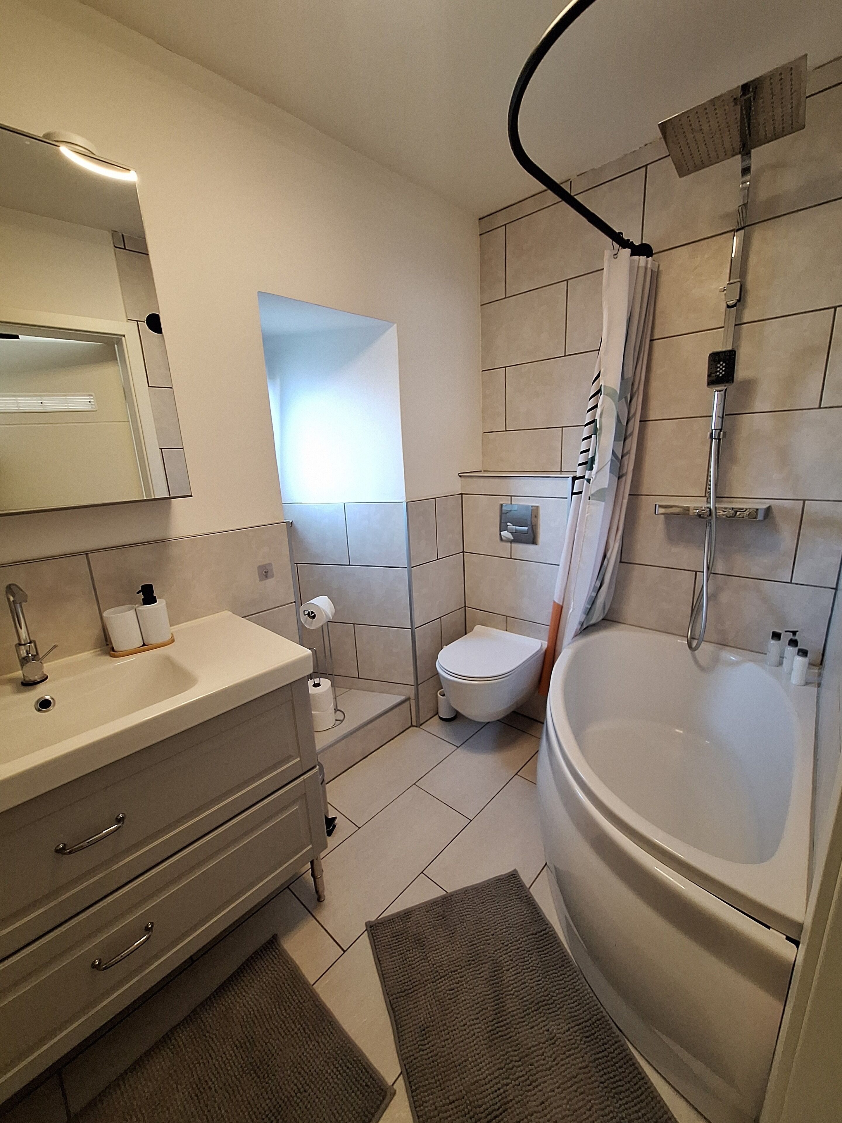 Un baño moderno con lavamanos, inodoro y bañera.