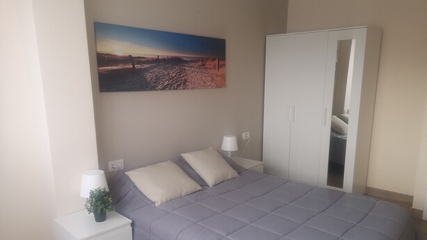 A bedroom with a bed, nightstands, a wardrobe, and a painting on the wall. - Full apartment 13 beds and 3 bathrooms near the airport North La Laguna Tenerife (La Laguna)