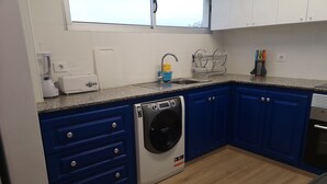 A kitchen with blue cabinets, a washing machine, a sink, and a countertop. - Full apartment 13 beds and 3 bathrooms near the airport North La Laguna Tenerife (La Laguna)