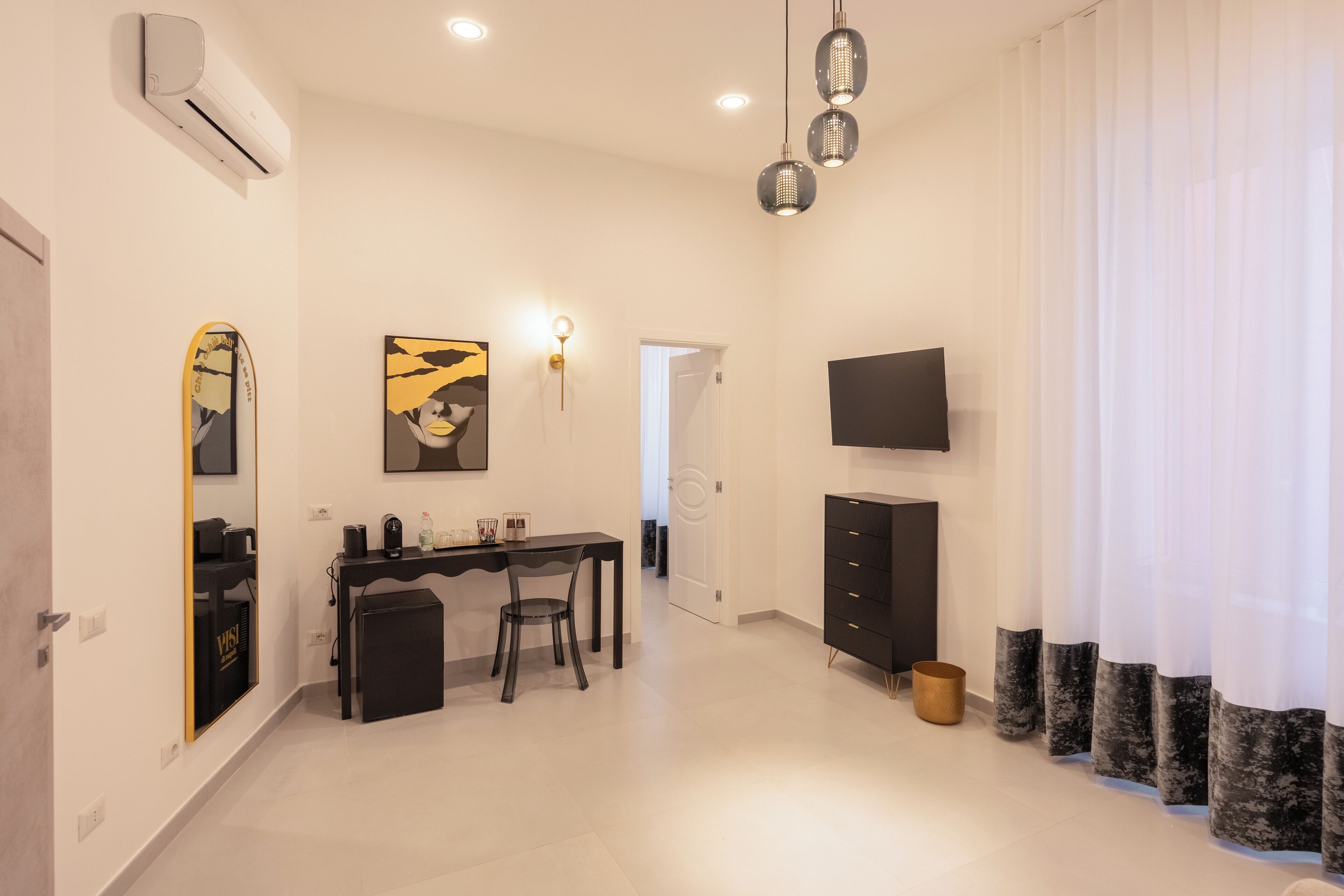 Une chambre d’hôtel moderne équipée d’un bureau, d’une chaise et d’un téléviseur à écran plat fixé au mur.