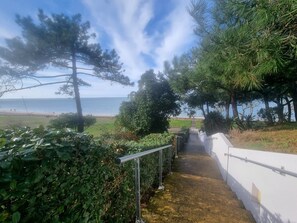 A pathway leading to a beach with a view of the sea, surrounded by greenery and trees. - 100 m from the beach, prime location (Arcachon)