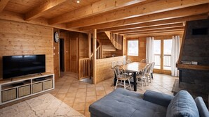 A wooden interior with a TV, dining area, and fireplace. - Apt or chalet near the slopes Les Orres (Les Orres)