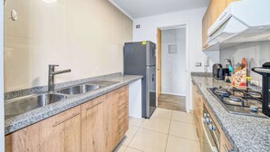 Eine moderne Küche mit Granit Arbeitsplatten, Edelstahlgeräten und Holzausstattung.