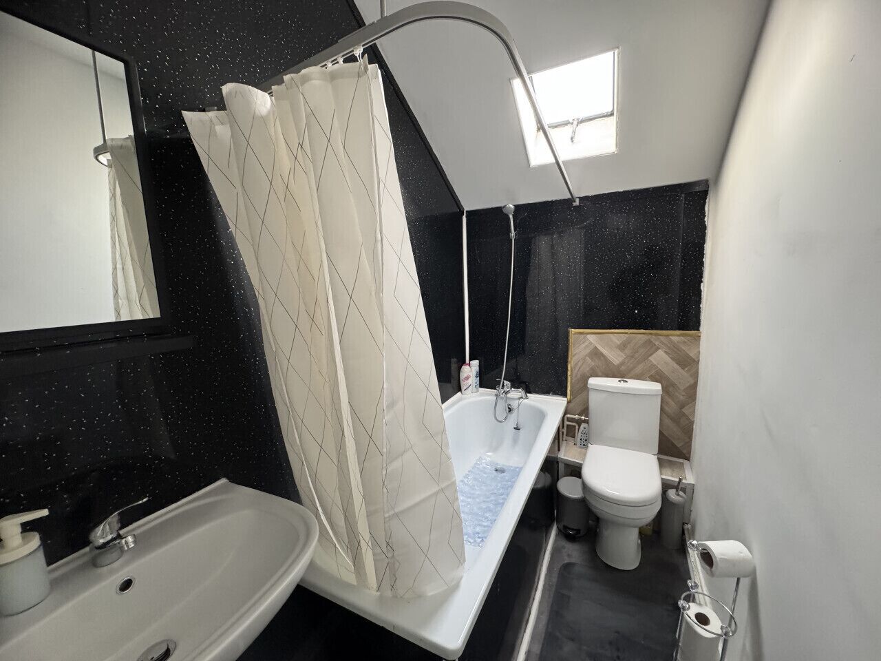 A modern bathroom with a bathtub, toilet, and sink.