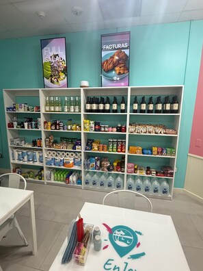 A pharmacy with shelves stocked with various health products, a counter with medical supplies, and two informational posters on the wall. - Beachfront condo w/pool, gym & direct beach access (Hollywood)