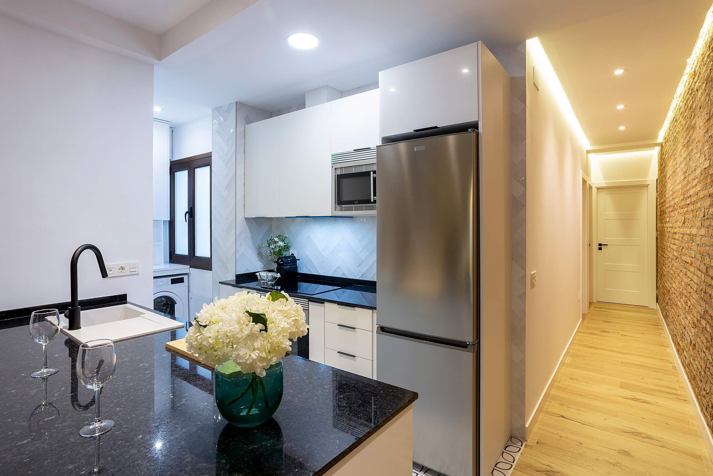 A modern kitchen with a stainless steel refrigerator, a microwave, and a sink.