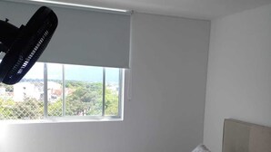 Ein Schlafzimmer mit Bett, Fenster und Deckenventilator.