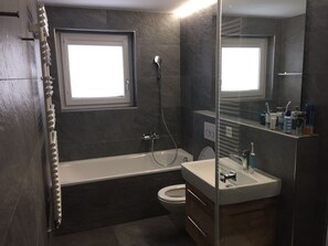 A modern bathroom with a bathtub, toilet, and sink. - Cosy apartment, great views and ski in ski out(conditions permitting) (Saas-Fee)