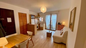 Un espace de vie compact comprenant un coin repas, une kitchenette et un canapé.