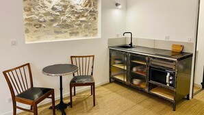 A small kitchen with a dining table and chairs, a refrigerator, and a microwave. - "Ribot" Coquet studio in the heart of Sète, Air conditioning & Wifi (Sète)