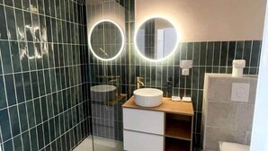 A modern bathroom with a glass shower enclosure, a white sink with a wooden vanity, and a toilet. - "Tango" T2 Air-conditioned, Town-centre, Parking, Wifi (Sète)