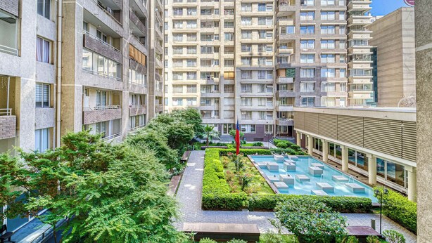 A high-rise residential building with multiple balconies, a rooftop garden, and a swimming pool. - Live Downtown 2BR Apartment W/ 2 TV near Downtown (Santiago)