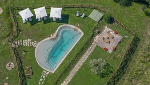 An aerial view of a property with a swimming pool, outdoor seating, and a fenced area. - Podere Bagnoli farmhouse with swimming pool and sea view (Toscana)