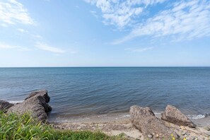 A coastal landscape with large rocks and calm water.