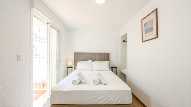 Une chambre d’hôtel avec un lit, une table de chevet, une lampe et un tableau encadré au mur.