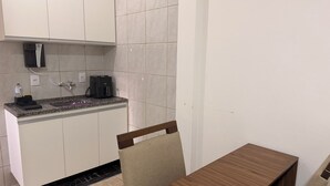 A small kitchenette with a sink, a coffee maker, and a countertop. - Private studio apartment with Smart TV and air conditioning. (Belo Horizonte)