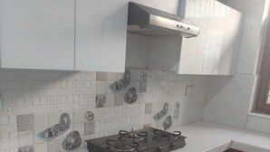 A kitchen with white cabinets, a tiled backsplash, and a gas stove.