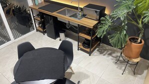 Eine kleine Küche mit Mikrowelle, Spüle und einem Blumentopf.