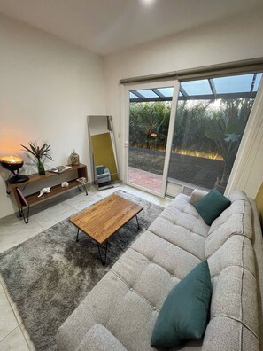 A modern living room with a sofa, a coffee table, and a wooden console table with decorative items.