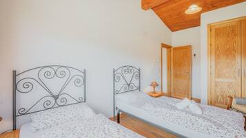 Une chambre avec deux lits, un plafond en bois et une porte en bois.