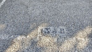 Um parque de estacionamento com uma barreira de metal e um bordilho de betão.