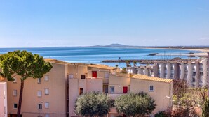 Une zone résidentielle côtière avec des bâtiments, un ciel dégagé et une vue sur la mer.