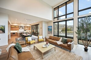A spacious living area with a large window, a dining area, and a kitchen. - *NEW Lakefront Luxury | Rooftop Deck, Views, Dock, Hot Tub & Spa Amenities (Chelan)