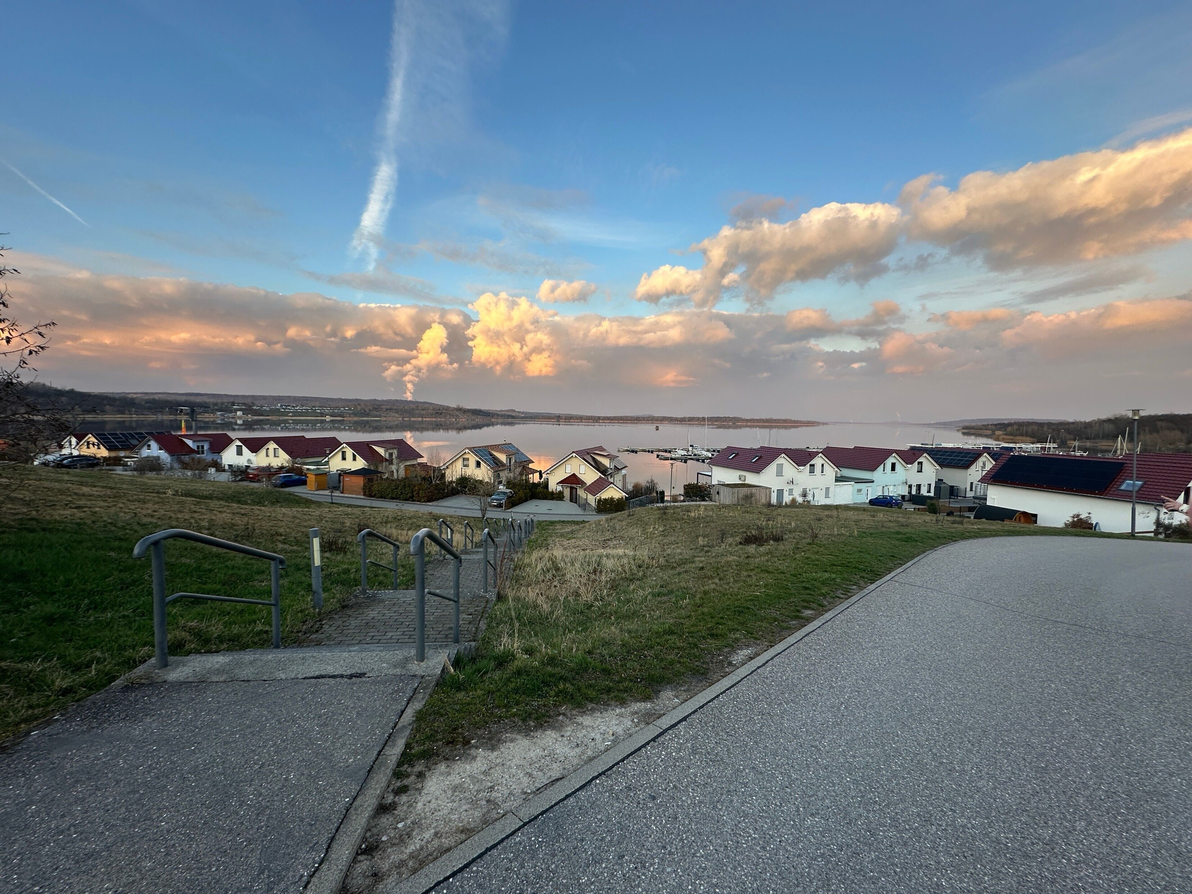 Ein Küstenwohngebiet mit Häusern, einem Yachthafen und blauem Himmel.