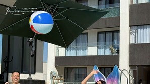 A swimming pool with a person on a colorful inflatable ring, another person in the water, and a beach ball hanging above. - 1BR Luxury Suites near Airport with pool/gym/Cityview (Nairobi)
