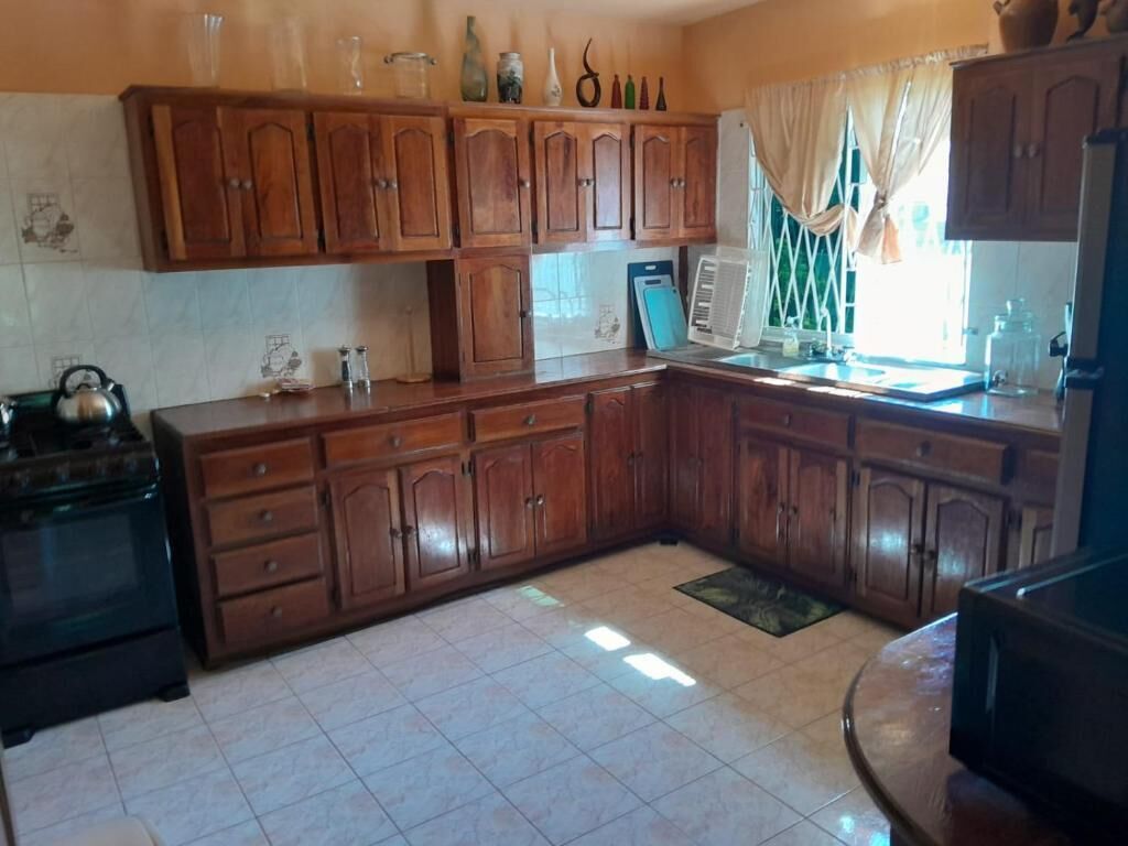 A kitchen with wooden cabinets, a stove, and a microwave.