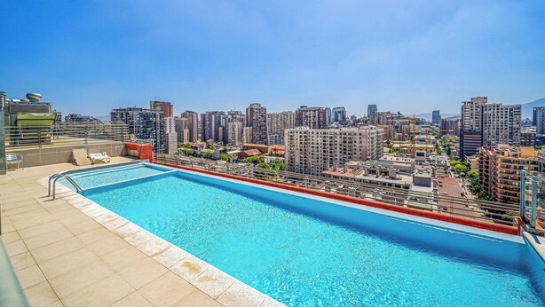 A rooftop swimming pool with a cityscape view. - Espacio Lira - 1D & Wifi (Santiago)