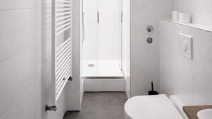 Une salle de bain moderne équipée d’une douche, de toilettes et d’un lavabo.