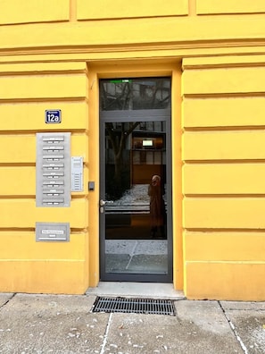 A yellow building with a door, a mailbox, and a sign indicating '12a'. - Artist room 2.4 - the aristocratic (Gera)